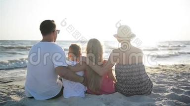母亲、<strong>父亲</strong>、儿子和<strong>女儿</strong>在海边拥抱的后景。